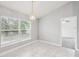 Bright dining area featuring tile flooring, a modern chandelier, and abundant natural light from a large window at 5134 Jenson Ave, Spring Hill, FL 34608