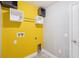 Efficient laundry area with bright yellow wall, functional shelving, and essential utility connections at 5134 Jenson Ave, Spring Hill, FL 34608