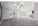 Open-concept living area with high ceilings, neutral paint, large windows, and seamless access to the kitchen at 5134 Jenson Ave, Spring Hill, FL 34608