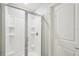 Modern shower features white tiles, a glass door, and built-in shelves at 5134 Jenson Ave, Spring Hill, FL 34608