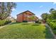 Expansive backyard offers a manicured lawn, lush landscaping, privacy hedges, and glimpses of the pool at 5910 La Rosa Ln, Apollo Beach, FL 33572