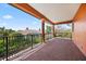 Outdoor balcony with brick flooring, elegant columns, and wrought-iron railing with scenic neighborhood views at 5910 La Rosa Ln, Apollo Beach, FL 33572