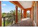 Exterior balcony with brick flooring, wrought iron railings, and tall stone columns overlooking lush landscaping at 5910 La Rosa Ln, Apollo Beach, FL 33572