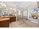 Bright bathroom with a walk-in shower, tub and dual sink vanity with marble countertops and lots of lighting at 5910 La Rosa Ln, Apollo Beach, FL 33572
