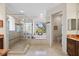 Luxurious bathroom with a glass-enclosed shower, soaking tub, and marble countertops with elegant vanities at 5910 La Rosa Ln, Apollo Beach, FL 33572