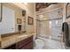 Well-lit bathroom with a granite countertop, vanity and a shower-tub with a sliding glass door at 5910 La Rosa Ln, Apollo Beach, FL 33572