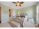 Comfortable bedroom with light green walls, a unique ceiling fan, and a decorative iron bed frame at 5910 La Rosa Ln, Apollo Beach, FL 33572