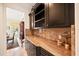 This area is a butler pantry with stone countertops and dark wood cabinets for functionality and style at 5910 La Rosa Ln, Apollo Beach, FL 33572