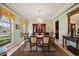Elegant dining room featuring a chandelier, large windows, and a decorative china cabinet at 5910 La Rosa Ln, Apollo Beach, FL 33572