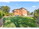 Expansive backyard featuring a lush lawn and a well-maintained orange two-story home at 5910 La Rosa Ln, Apollo Beach, FL 33572