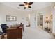 Neutral colored office with a ceiling fan, a dark desk, and doors leading to other areas of the home at 5910 La Rosa Ln, Apollo Beach, FL 33572