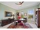 Office with a ceiling fan, a red accent chair, and natural lighting from two windows at 5910 La Rosa Ln, Apollo Beach, FL 33572