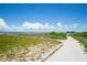 Scenic beach access path framed by lush greenery and the tranquil waters of Apollo Beach at 5910 La Rosa Ln, Apollo Beach, FL 33572