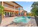 A luxurious pool and spa sit behind an orange two-story house with a patio at 5910 La Rosa Ln, Apollo Beach, FL 33572