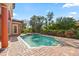 Private backyard pool with a lush garden, brick pavers, and serene landscaping at 5910 La Rosa Ln, Apollo Beach, FL 33572
