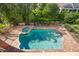 Aerial view of a private backyard pool and spa surrounded by lush landscaping and a brick-paved patio at 5910 La Rosa Ln, Apollo Beach, FL 33572