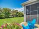 Inviting backyard featuring a screened-in lanai with Adirondack chairs and lush tropical landscaping at 6527 Mayport Dr, Apollo Beach, FL 33572