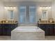 Bathroom features a luxurious soaking tub nestled between dual vanities and windows at 6527 Mayport Dr, Apollo Beach, FL 33572