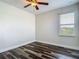 Bright bedroom features updated flooring, ceiling fan, and natural light from a window at 6527 Mayport Dr, Apollo Beach, FL 33572