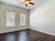 Bedroom featuring hardwood floors, a ceiling fan, and large windows, creating a comfortable and inviting space at 6527 Mayport Dr, Apollo Beach, FL 33572