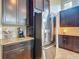 Spacious kitchen boasts stainless steel refrigerator, granite counters, tile backsplash and dark wood cabinetry at 6527 Mayport Dr, Apollo Beach, FL 33572