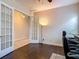 Spacious office featuring dark wood floors, french doors, and a modern floor lamp at 6527 Mayport Dr, Apollo Beach, FL 33572