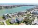 A scenic aerial view of a waterfront neighborhood, showing homes, trees, ocean views and boat docks offering insight to potential buyers at 720 Bay Esplanade, Clearwater Beach, FL 33767