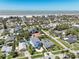 An aerial view captures neighborhood homes, trees and the beach, highlighting the community's scenic surroundings and coastal living at 720 Bay Esplanade, Clearwater Beach, FL 33767