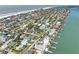 Coastal homes are nestled among lush palm trees near a beautiful sandy beach and sparkling turquoise water at 720 Bay Esplanade, Clearwater Beach, FL 33767