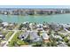Scenic aerial view of waterfront homes with pool, nestled near tranquil waters and lush greenery at 720 Bay Esplanade, Clearwater Beach, FL 33767