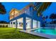 Stunning backyard with a sparkling blue swimming pool, covered patio, and lush green lawn at 720 Bay Esplanade, Clearwater Beach, FL 33767