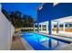Beautiful backyard featuring a sparkling in-ground pool, a spacious covered patio, and tropical landscaping at 720 Bay Esplanade, Clearwater Beach, FL 33767