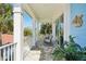 Inviting covered balcony with rocking chairs, white railings and lovely exterior home details at 720 Bay Esplanade, Clearwater Beach, FL 33767