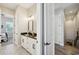 Bathroom featuring double sinks, black countertop, white cabinets, and decorative tile flooring at 720 Bay Esplanade, Clearwater Beach, FL 33767