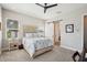 Bright bedroom featuring a ceiling fan, large windows, light gray walls, and barn door access to the en-suite bathroom at 720 Bay Esplanade, Clearwater Beach, FL 33767