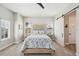 Calm bedroom with large windows, a ceiling fan, light gray walls, and an en-suite bathroom at 720 Bay Esplanade, Clearwater Beach, FL 33767