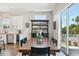 Bright dining room boasts a large wood table, stylish rug, and sliding doors to the outdoor balcony at 720 Bay Esplanade, Clearwater Beach, FL 33767