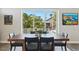 Dining table in a naturally lit dining room, with a view of tropical trees through the sliding glass doors at 720 Bay Esplanade, Clearwater Beach, FL 33767