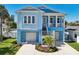 Charming two-story home featuring double garages, lush landscaping, and a welcoming front entrance at 720 Bay Esplanade, Clearwater Beach, FL 33767