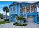 Stunning elevated two-story home with a spacious porch, staircase, and meticulously landscaped front yard at 720 Bay Esplanade, Clearwater Beach, FL 33767