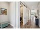 Hallway with wood-look floors, leading to laundry room with sliding barn door and front load washer and dryer at 720 Bay Esplanade, Clearwater Beach, FL 33767