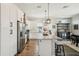 Spacious eat-in kitchen with granite counters, stainless appliances, an island with pendant lights, and stylish bar seating at 720 Bay Esplanade, Clearwater Beach, FL 33767
