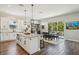 Bright eat-in kitchen featuring granite counters, wood floors, island with pendant lights, and an adjacent dining area with balcony access at 720 Bay Esplanade, Clearwater Beach, FL 33767
