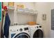 Laundry room with white front load washer and dryer and wire shelving at 720 Bay Esplanade, Clearwater Beach, FL 33767