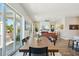 Open floor plan showcasing the dining area, living room, and balcony access with lush, green tropical trees at 720 Bay Esplanade, Clearwater Beach, FL 33767