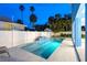 Stunning backyard oasis featuring a sparkling pool, manicured landscaping, and a privacy fence at 720 Bay Esplanade, Clearwater Beach, FL 33767