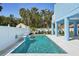 Sparkling in-ground pool with tranquil waterfall feature, enclosed by a white fence for privacy and peaceful backyard retreat at 720 Bay Esplanade, Clearwater Beach, FL 33767