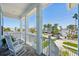 Relaxing front porch showcasing comfortable seating and a serene neighborhood view, perfect for unwinding at 720 Bay Esplanade, Clearwater Beach, FL 33767