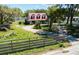 Exterior view of the home with a red roof and a fenced yard with mature trees at 7218 Turkey Creek Rd, Plant City, FL 33567