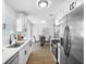 Well-lit kitchen featuring stainless steel appliances, white cabinets, and a dining area at 8422 85Th Ct, Seminole, FL 33777